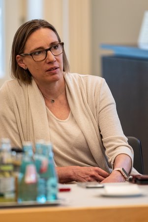 Öffnet eine Lightbox: Eine Frau hört zu 