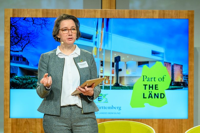 Öffnet eine Lightbox: Yvonne Zwick (BAUM e.V.), steht auf der Bühne Yvonne Zwick (BAUM e.V.)