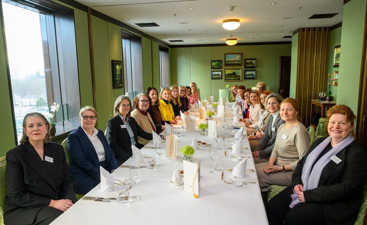 Öffnet eine Lightbox: Teilnehmerinnen an der gedeckten Tafel