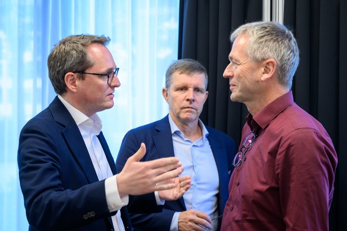 Öffnet eine Lightbox: Dominik Lamminger im Gespräch mit zwei Personen 